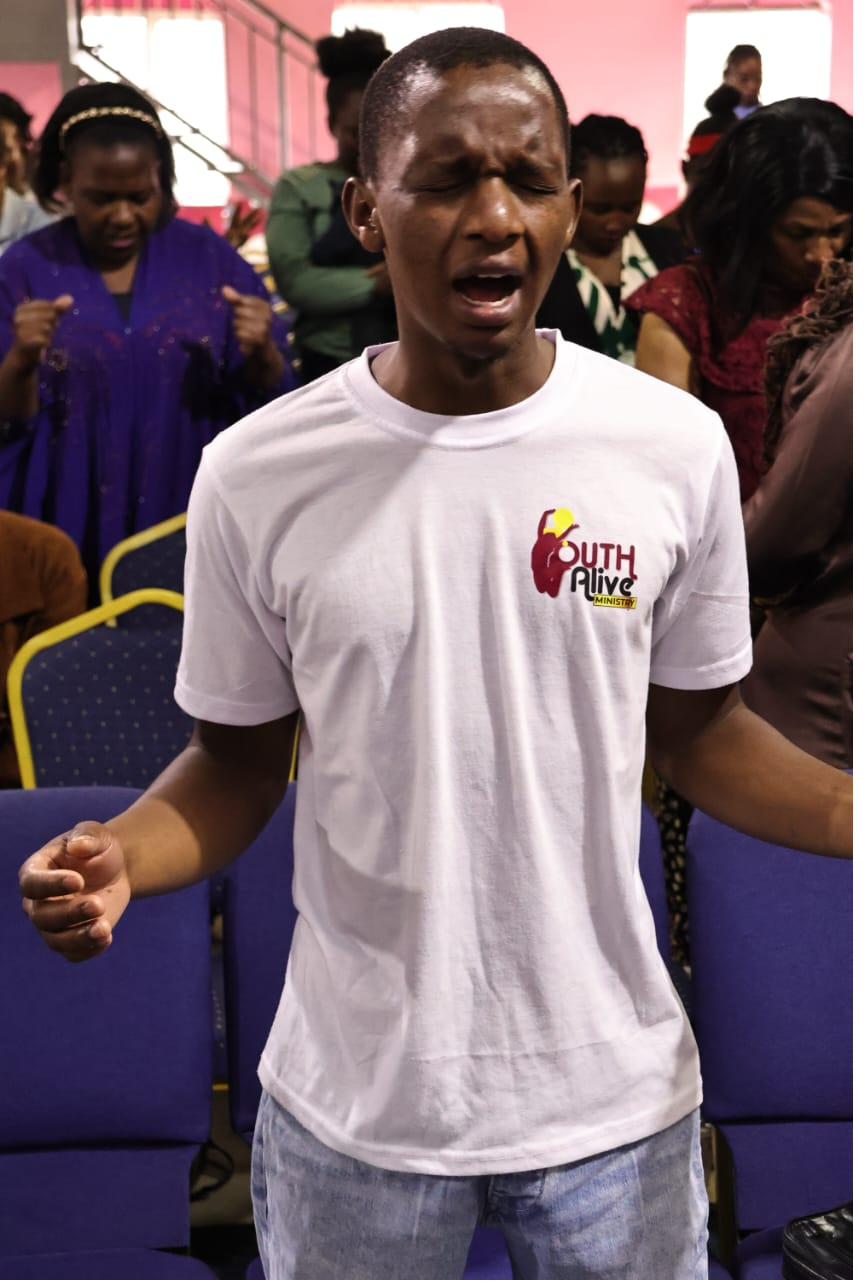 A young member in prayer at Youth Alive